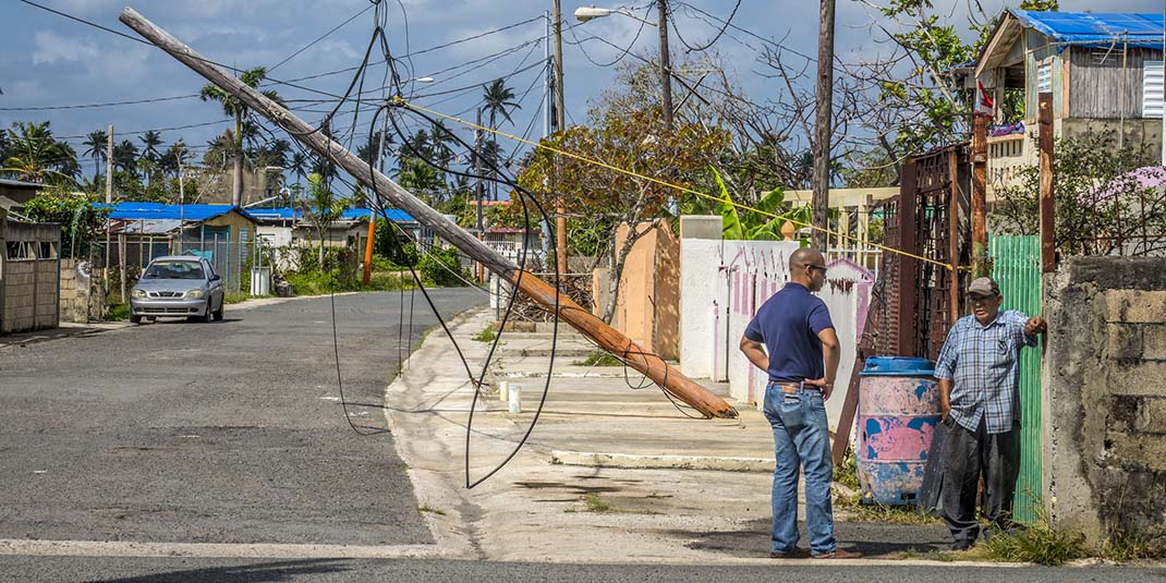 Two people clean up in the aftermath of Hurricane Maria in Puerto Rico