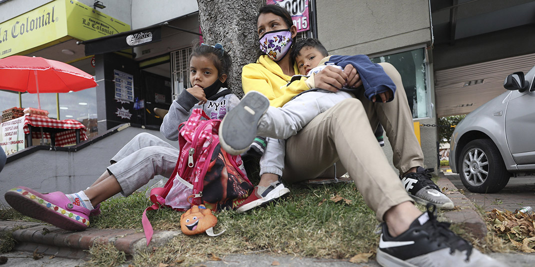 Venezuelan migrants rest outside a strip mall in Bogota, Colombia.