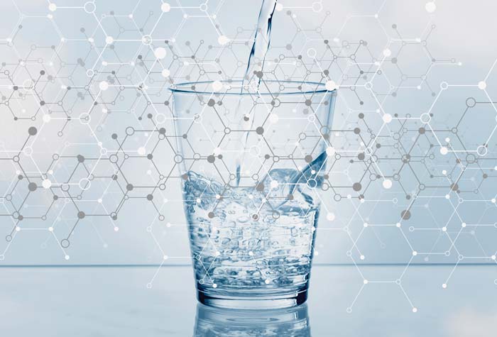 Photo illustration of chemical compound references overlaying a glass of water