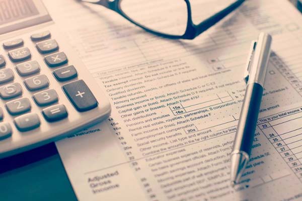 Tax form with calculator, pen, glasses