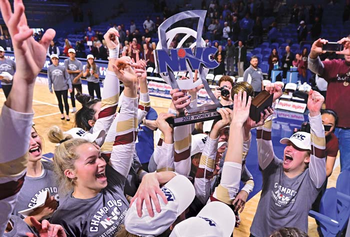 The women's volleyball team hoisting the trophy in celebration