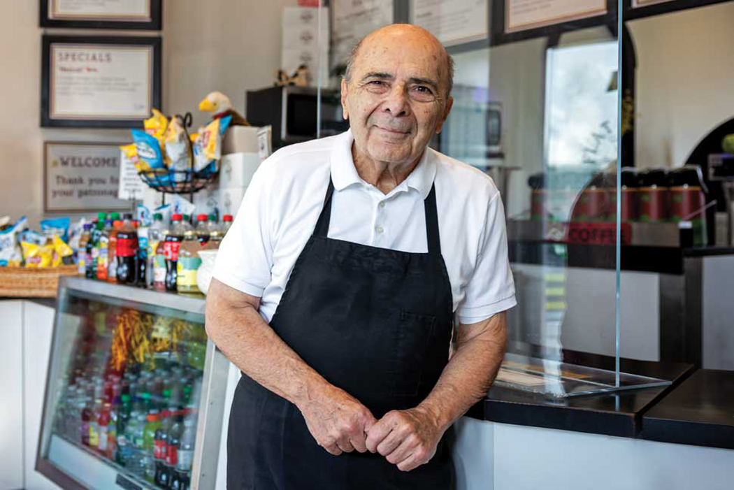 Photo of John Acampora at the counter of his Flat Breads shop
