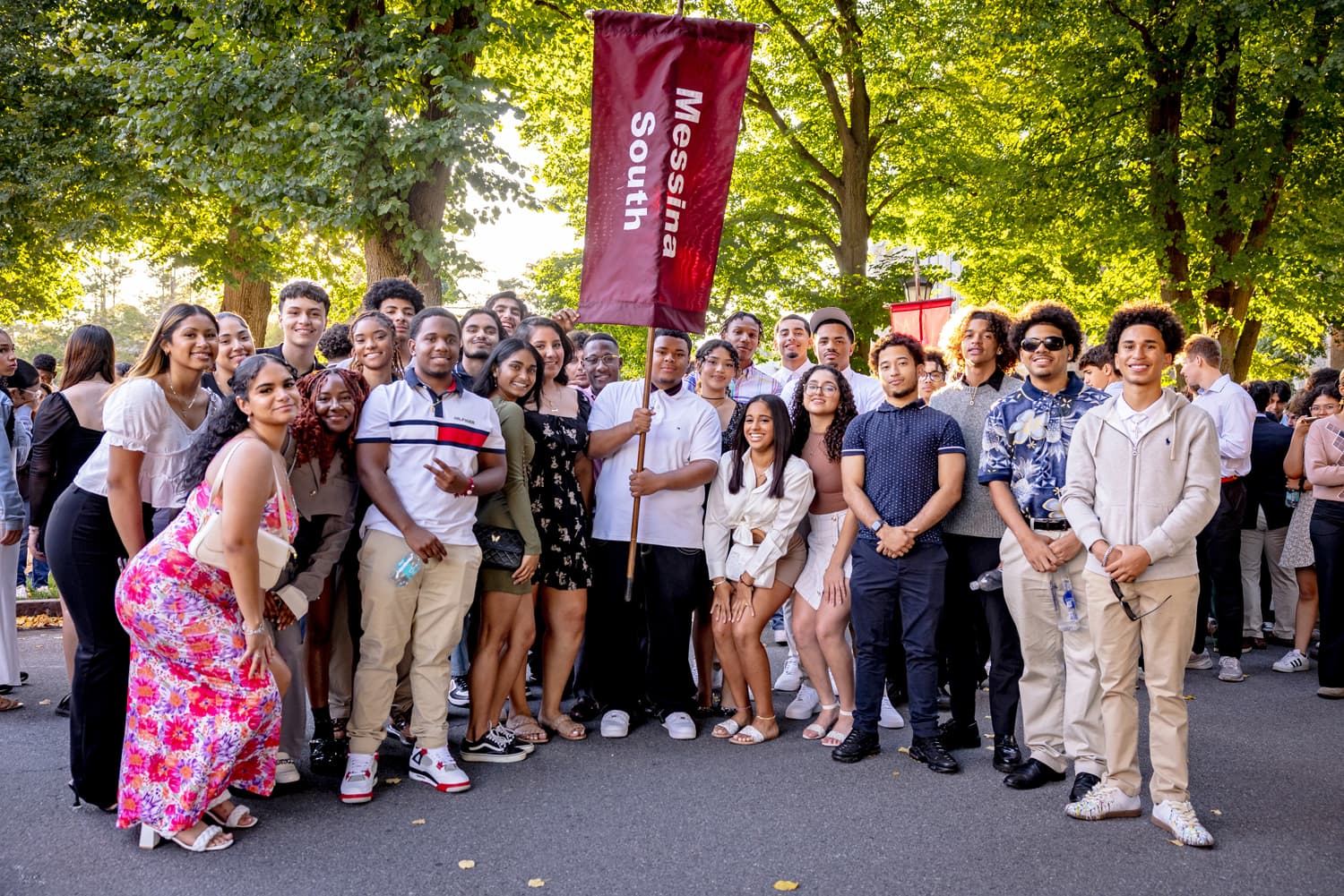 Messina College students gathered holding a class banner