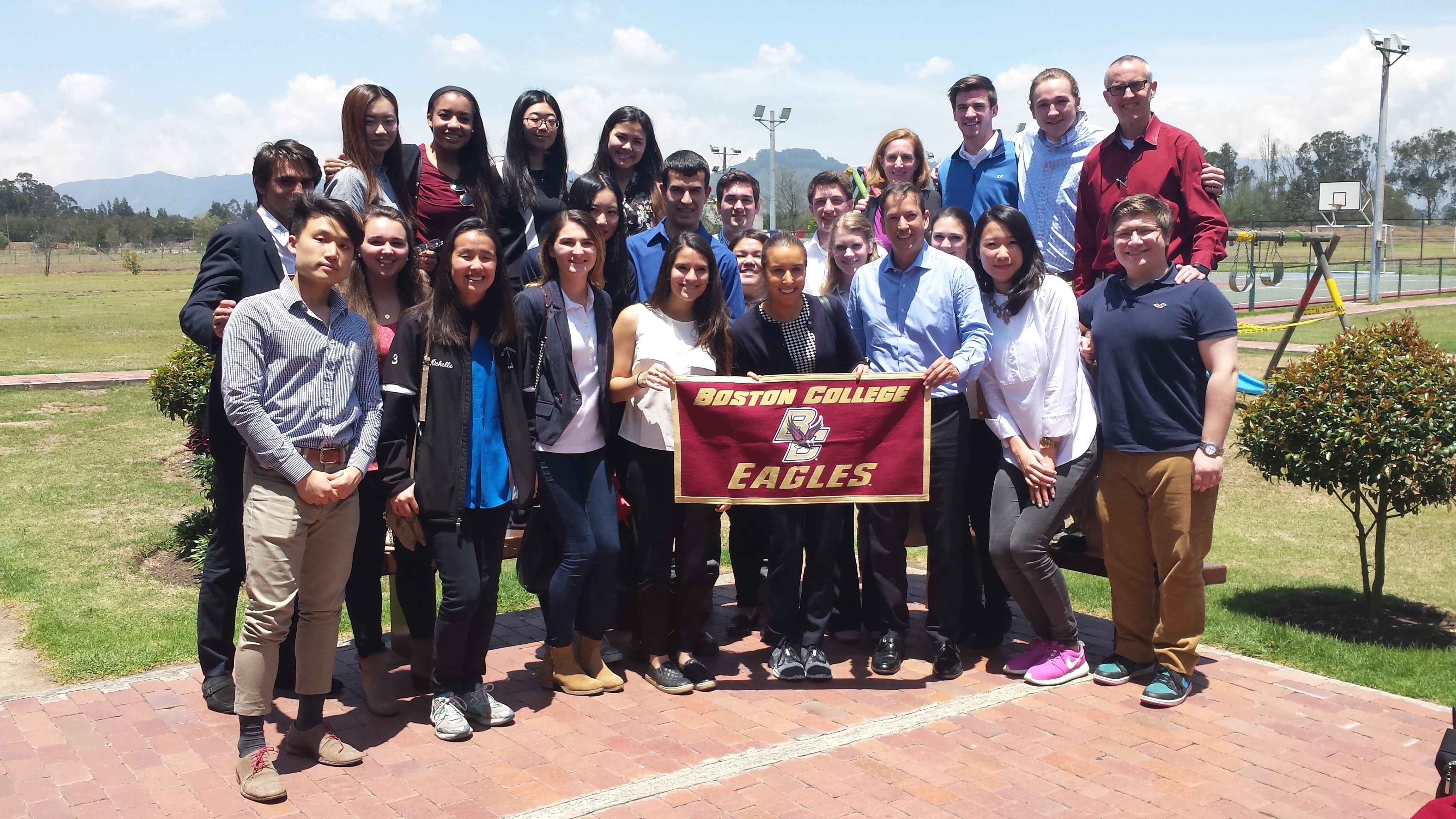 group of BC students, alumni, and professors in Bogota posing with a BC flag