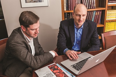Jerry Kane and Sam Ransbotham looking at a computer screen in an office